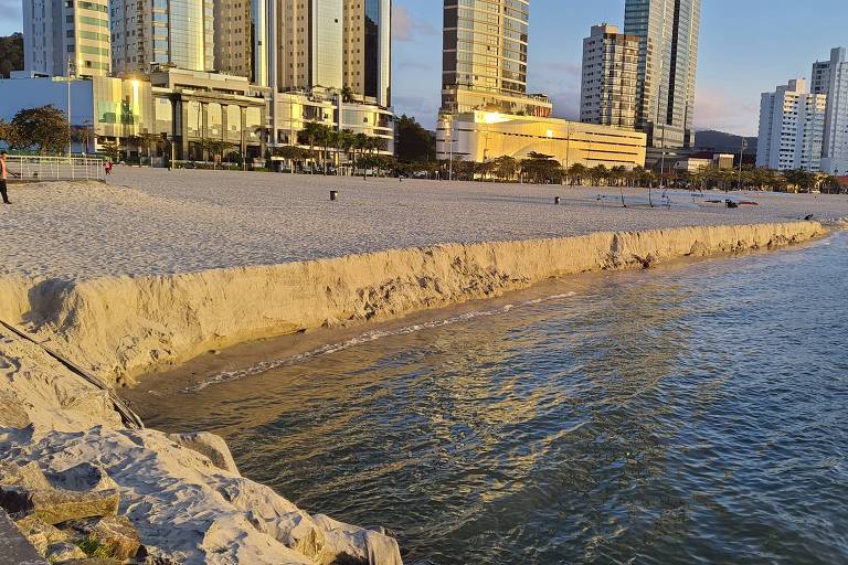 faixa de areia no mar com prédios ao fundo