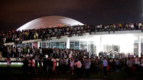 BRASILIA, DF, BRASIL, 17-06-2013: Manifestantes invadem a cúpula e o gramado do prédio do Congresso Nacional, eles protestam contra o aumento da tarifa do transporte coletivo, corrupção e gastos com a Copa do Mundo, 2014, em Brasília (DF).  Imagem faz parte do documentario 