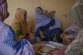 Iselekhe Jeilaniy, center, has lunch with female relatives and friends at her divorce party in Ouadane, a small town in the desert region of central Mauritania, April 24, 2023. (Laura Boushnak/The New York Times)
