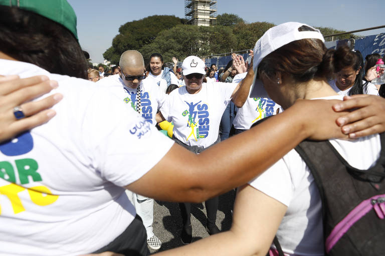 Fiéis que participam da Marcha para Jesus em São Paulo fazem oração
