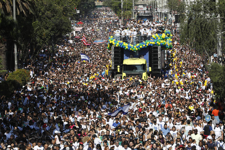 Uma multidão caminha junto a trios elétricos rumo a Santana, na zona norte de São Paulo, durante a 31ª edição da Marcha para Jesus, que acontece nesta quinta-feira (8), em São Paulo