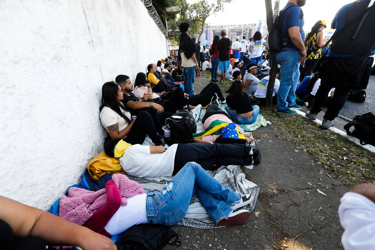 Fiéis transformam calçada em sofá para descansar após caminhada na Marcha para Jesus, realizada nesta quinta-feira (8), em São Paulo