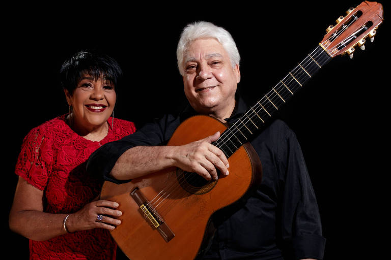 Em foto colorida, a cantora Rosa Passos e o violonista Lula Galvão posam para a câmera