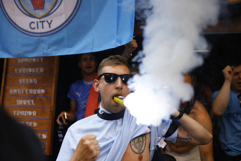 Torcedor do City coloca um sinalizador na boca durante festa antes do jogo final da Liga dos Campeões, em Istambul (Turquia)