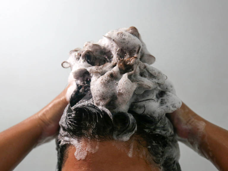 testa e cabelo de mulher que lava cabelo com espuma branca