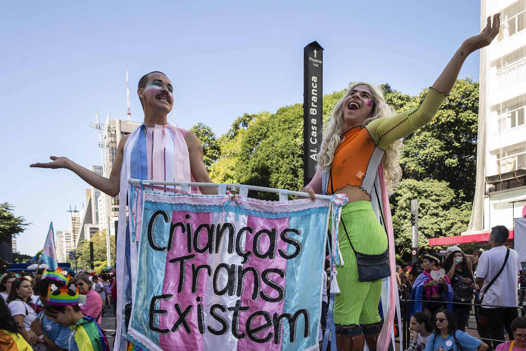 Participantes da 27ª edição da Parada do Orgulho LGBT+, em São Paulo, exibem cartaz com a frase 'Crianças trans existem'