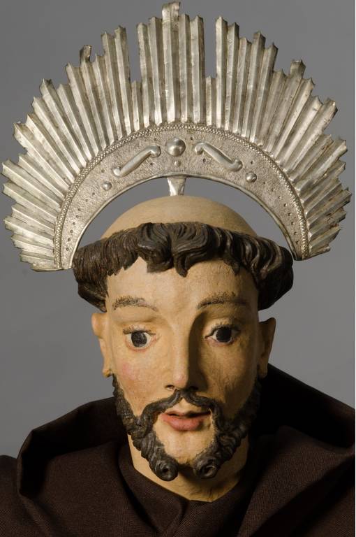 Imagem fechada no rosto de São Francisco de Assis Penitente, restaurada, com uma vestimenta marrom e um resplendor prateado na cabeça