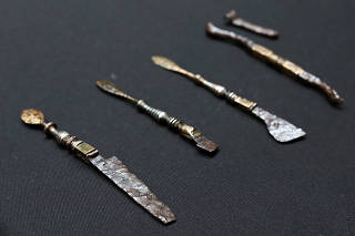 A photo provided by Rusznák Gábor/ELTE of some of the newly excavated instruments, which included forceps, a curet and three copper-alloy scalpels fitted with detachable steel blades and inlaid with silver an a Roman style. (Rusznák Gábor/ELTE via The New York Times)