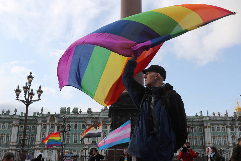 Manifestante agita bandeira com arco-íris durante ato pró-direitos LGBTQIA+ no centro de São Petersburgo, na Rússia 
