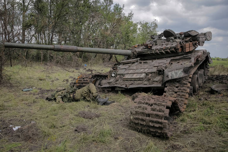 Soldado russo morto junto a tanque destruído em Storojeve, vilarejo retomado por Kiev em Donetsk