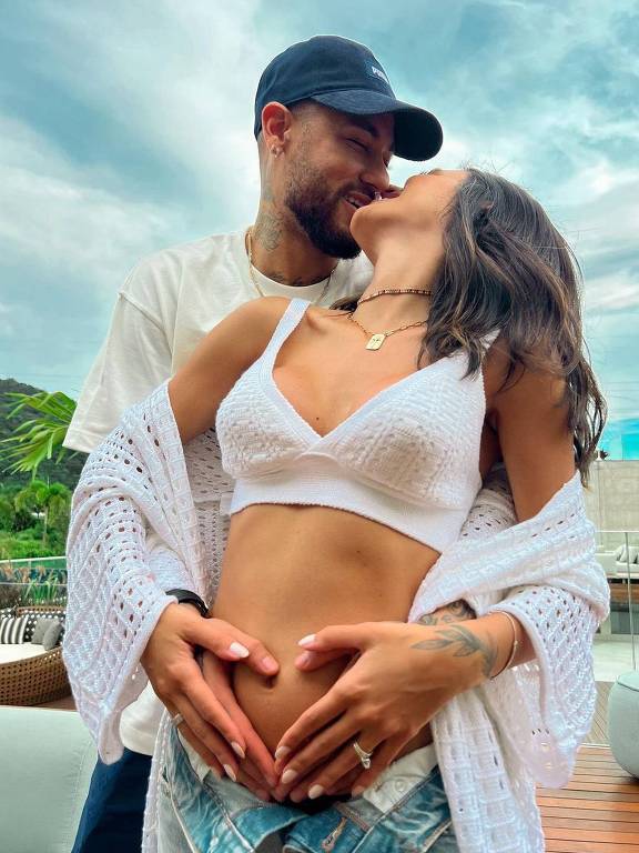 Neymar beija na boca a namorada, Bruna Biancardi; os dois estão abraçados e com as mãos sobre a barriga dela, que está grávida