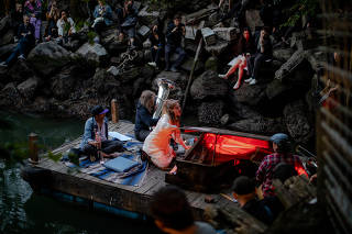 The singer and pianist Yuli BeÕeri closes a sunset performance in Queens at a cove where a combined sewer outfall meets the East River, June 9, 2023. (Natalie Keyssar/The New York Times)