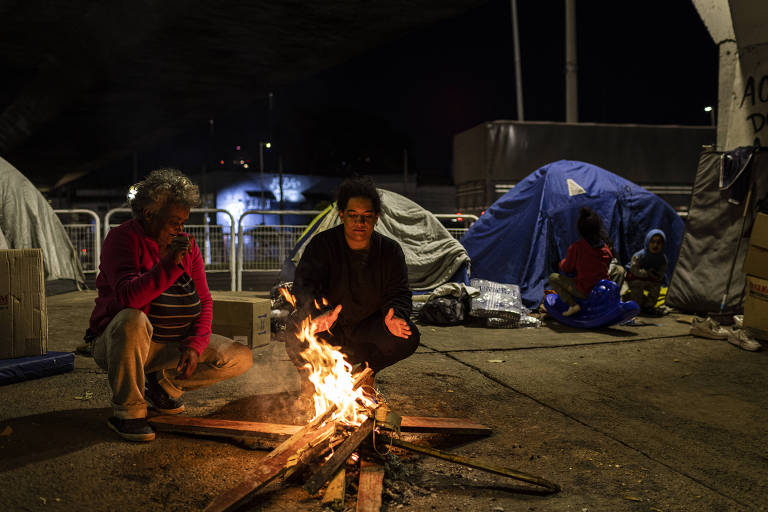 Com frio intenso, moradores de rua se aquecem em uma fogueira sob o viaduto Avenida Santo Amaro, na zona sul da cidade