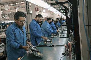 Workers for a Chinese company assemble parts for servers at the Lenovo Technology Center, in Apodaca, Mexico, Jan.18, 2023.