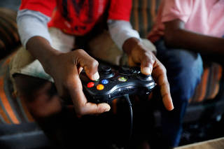 FILE PHOTO: Udom Idongesit, 13, uses a gaming controller as he plays a Vikseen Virtual video game, in his home in Ogun State
