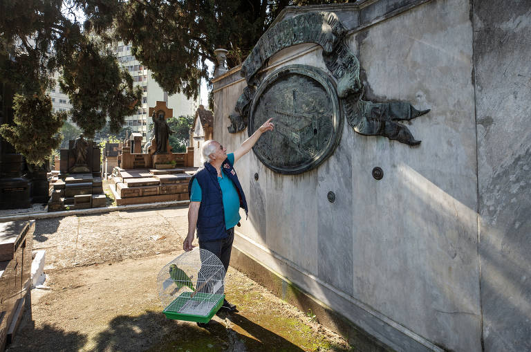 Bruno Giovannetti observa escultura no Tumulo dos Chapeleiros com seu papagaio Ermenegildo Zegna