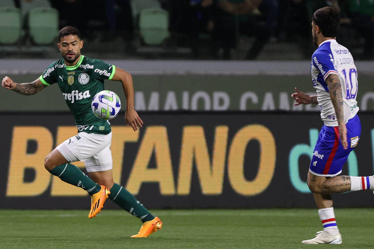 Dois jogadores de futebol disputam bola em campo