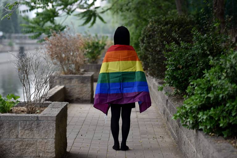 Estudante LGBT posa com a bandeira do arco-íris em Pequim