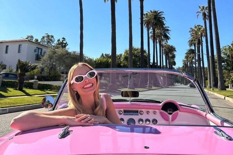 A atriz Margot Robbie num carro conversível cor de rosa