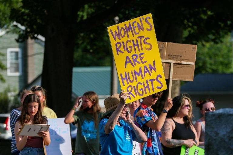Manifestando segurando cartaz em que se lê: 'Direitos das Mulheres são direitos humanos' durante marcha pelos direitos das mulheres nos EUA
