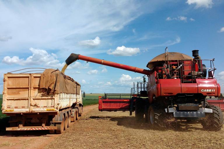 colheitadeira deposita grãos em caçamba de caminhão