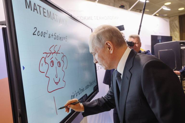 Putin desenha um rosto numa tela sensível ao toque durante visita na feira Ideias Fortes para um Novo Tempo, em Moscou