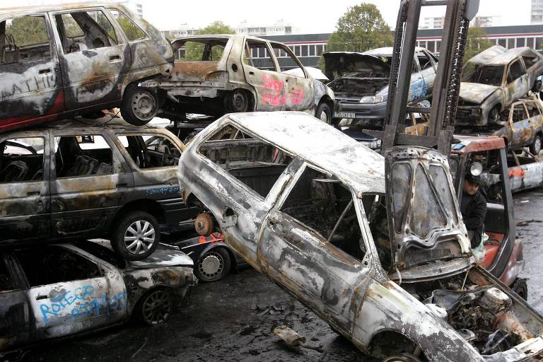 Carros empilhados após serem queimados nos protestos de 2005, em ferro-velho localizado no subúrbio de Grigny