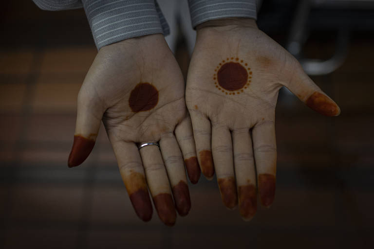 Pintura decorativa tradicional na mão de uma menina acampada no local