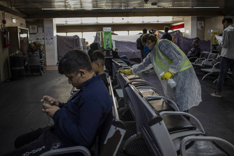 Equipes de limpeza do aeroporto desinfetam o local onde os afegãos estão acampados, devido ao surto de sarna