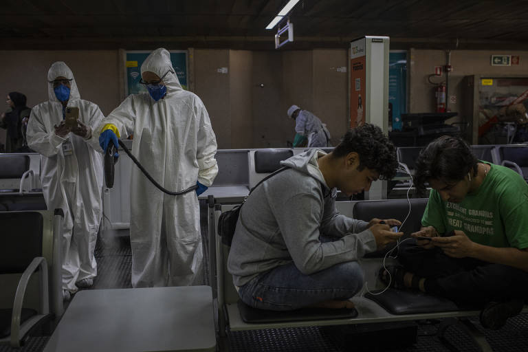 Equipes de limpeza do aeroporto desinfetam o local onde os afegãos estão acampados