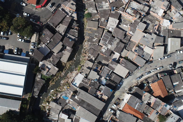 imagem aérea mostra córrego estreito cortando bairro de casas 