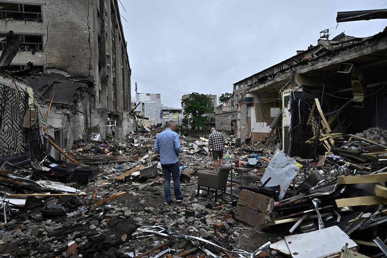 Moradores de Kramatorsk, no leste da Ucrânia, andam por destroços de prédios atingidos por míssil russo nesta semana, em ataque que deixou 12 mortos