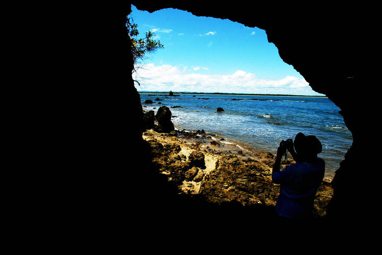 Turista tira foto na ilha da Pedra Furada, cartão postal da Península de Maraú (BA)