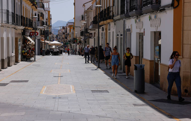 Locais e turistas caminhando na sombra para se proteger do calor durante as horas mais quentes do dia na cidade de Ronda, na Espanha