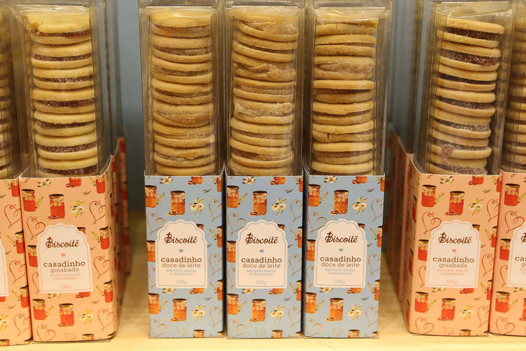 Imagem mostra caixas transparente com biscoitos recheados empilhados