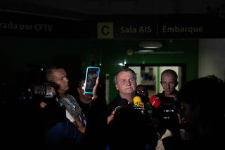 Brazil's former President Jair Bolsonaro talks with media upon his arrival at Brasilia International Airport