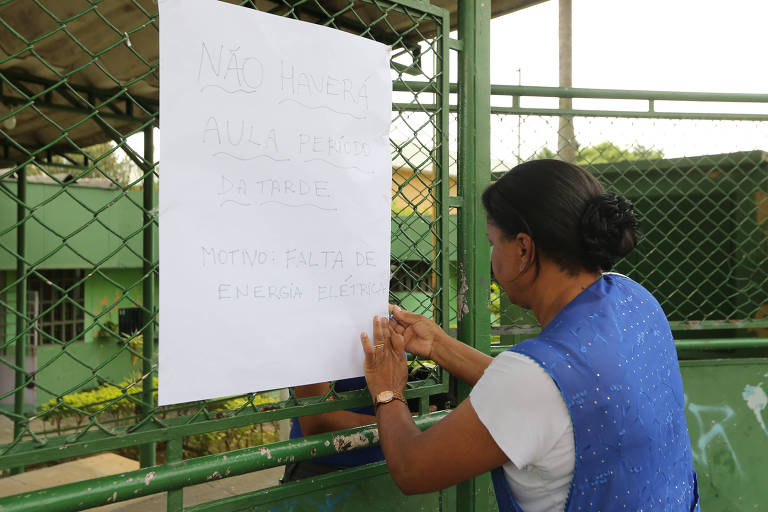 Mulher cola cartaz com aviso