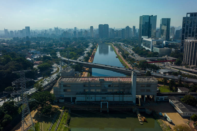 Imagem geral da Usina São Paulo, ao centro, com a fachada coberta por telas protetoras. A usina fica no rio Pinheiros