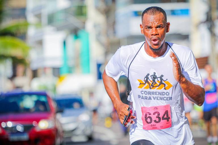 Imagem mostra Eder Sabino, um homem negro, correndo na prova de rua Correndo Para Vencer 2023