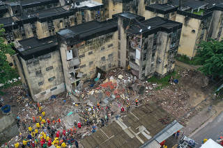 Rescue workers look for victims among debris of a building collapse in Recife, Pernambuco state
