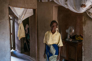 Khadija William, who used money from a cash relief program to buy a small solar panel to power a light and room fan, at her home in the village of Chipyali, Malawi, March 25, 2023. (Khadija Farah/The New York Times)