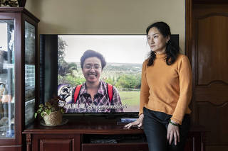 Bei Zhenying with an image of her husband, Ruan Xiaohuan, at their apartment in Shanghai, April 29, 2023. (The New York Times)