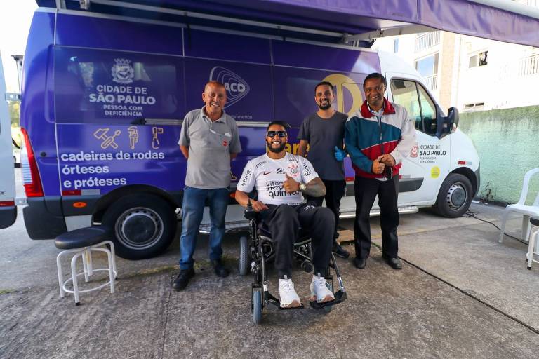 ohnny Nascimento da Silva e a equipe da van da Paraoficina Móvel, após a manutenção realizada em sua cadeira de rodas, no Jardim Selma, zona sul de São Paulo