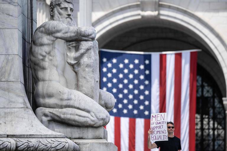 Manifestante pró-aborto exibe cartaz com a frase 'homens de bem apoiam igualdade para mulheres' em protesto no dia em que a decisão da Suprema Corte contrária ao aborto completou um ano, em Washington