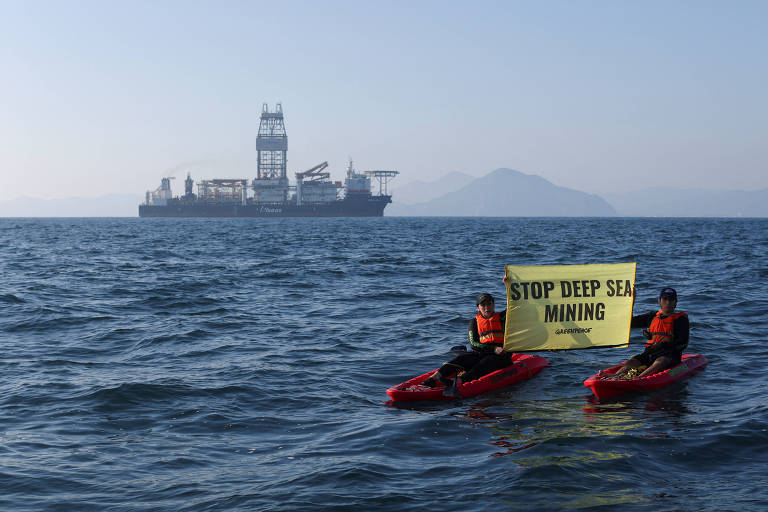 Ativistas em caiaques no meio do oceano seguram a faixa 'stop deep sea mining'