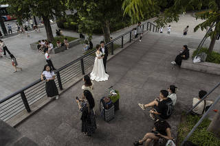 A couple has wedding photos taken near the Bund in Shanghai, China, July  5, 2023. (Qilai Shen/The New York Times)