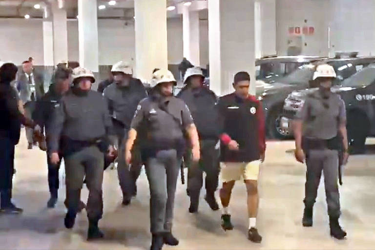 Sebastian Avellino Vargas é escoltado pela polícia após ser detido no Itaquerão; ele é suspeito de fazer gestos racistas contra a torcida do Corinthians
