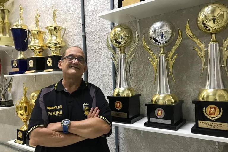 Fernando Ferretti posa em galeria de troféus do time de Jaraguá do Sul, onde conquistou vários de seus títulos no futsal; técnico morreu em 12/7/2023, aos 69 anos