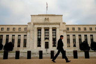 FILE PHOTO: A man walks past the Federal Reserve in Washington