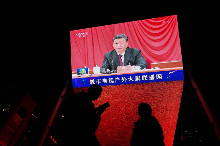 O líder chinês, Xi Jinping, no noticiário noturno da estatal CCTV no ar em uma TV de shopping de Pequim